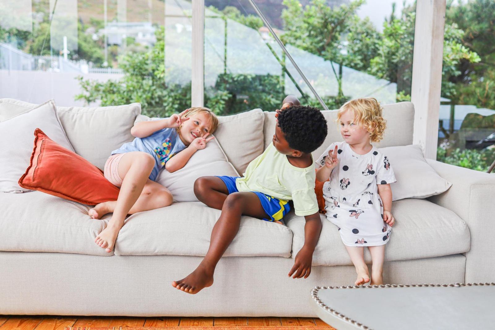 Kids laying and laughing on a couch at Lobster Villa by Nox Rentals