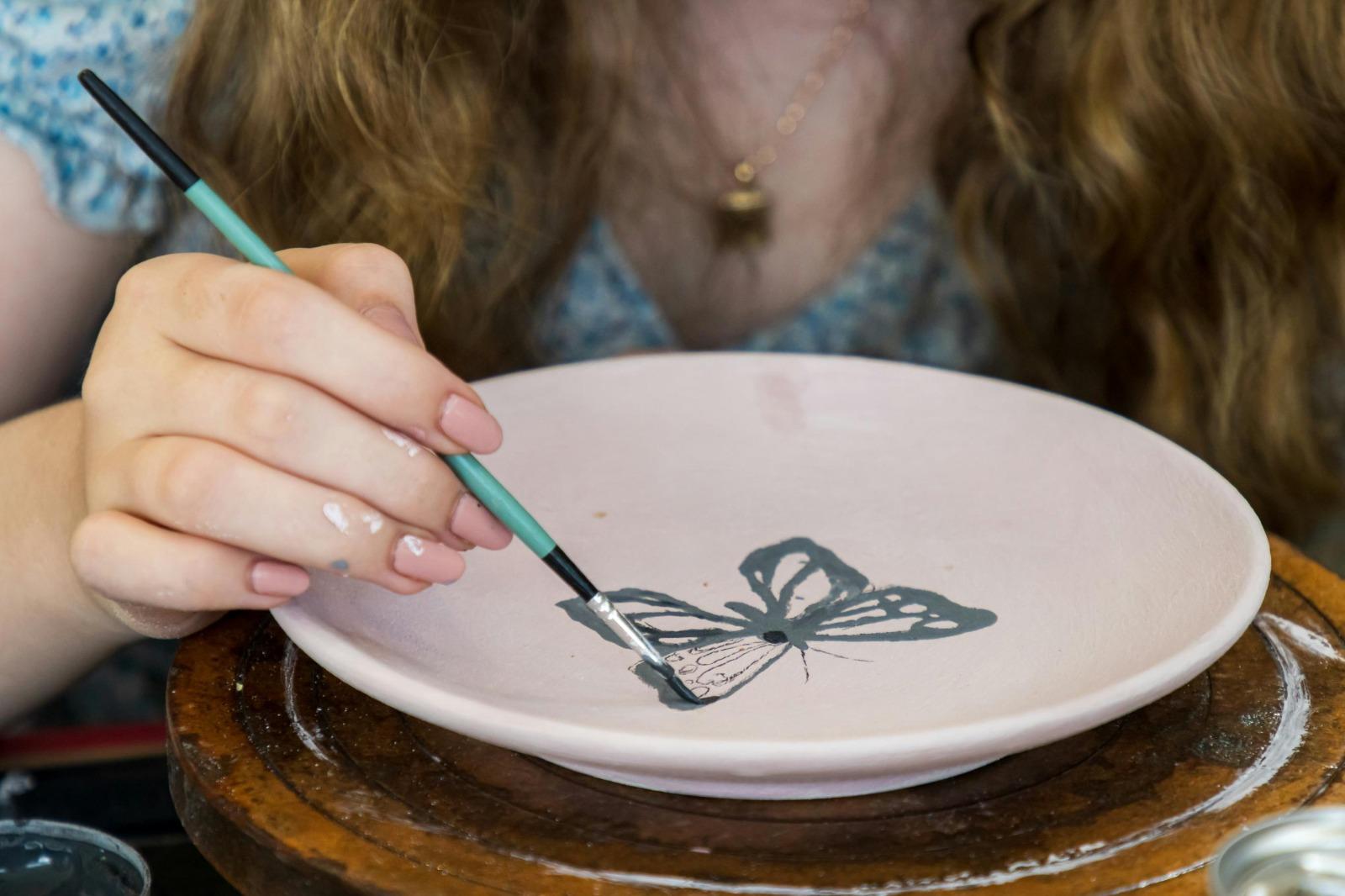 Woman painting pottery plate